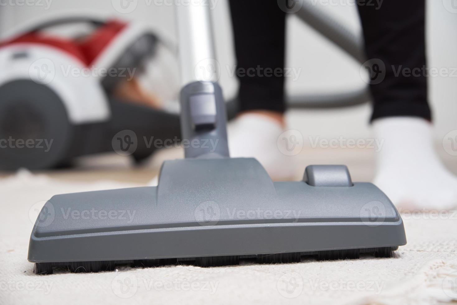 Woman use vacuum cleaner at the floor photo