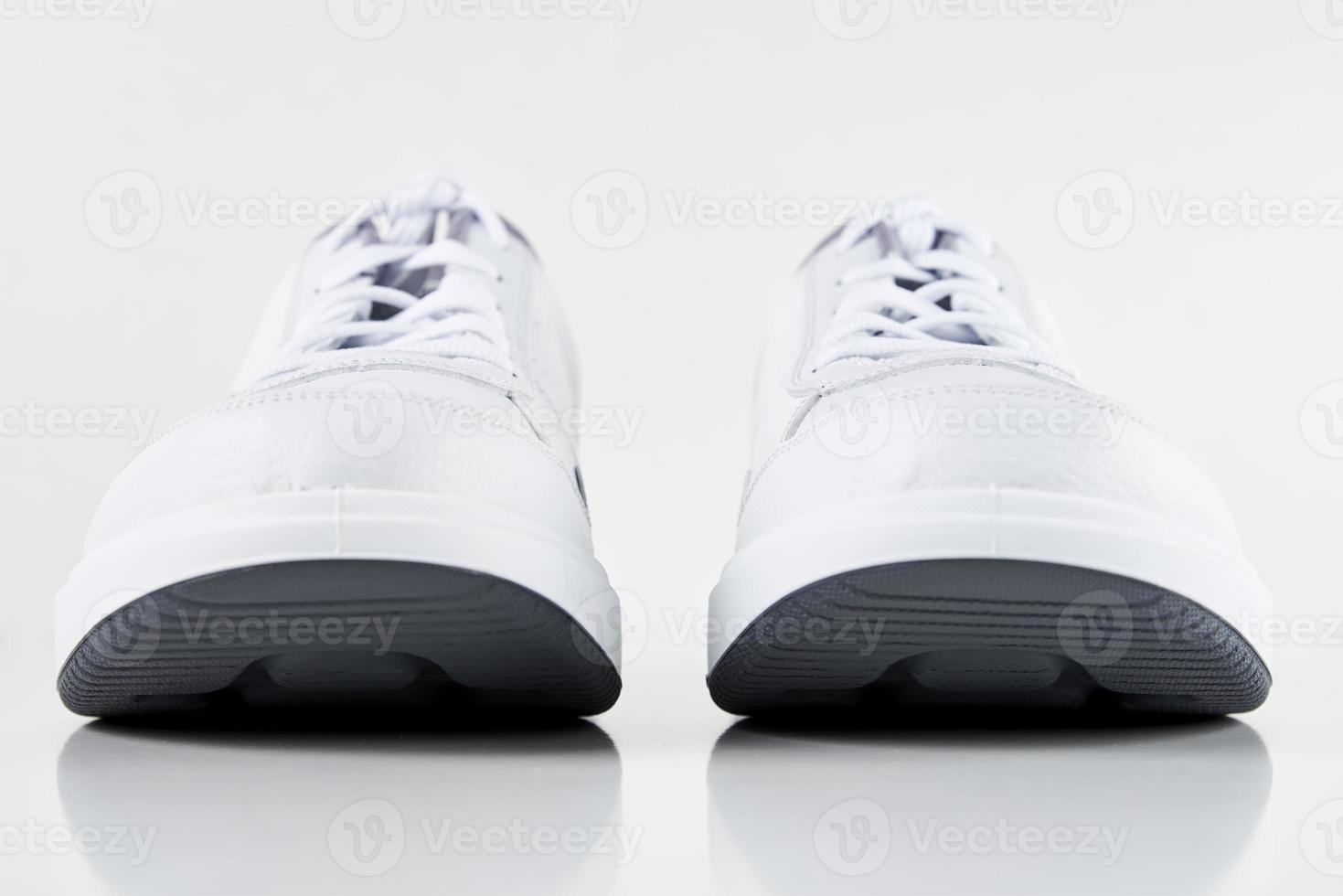 par de zapatillas masculinas blancas sobre fondo blanco aislado foto