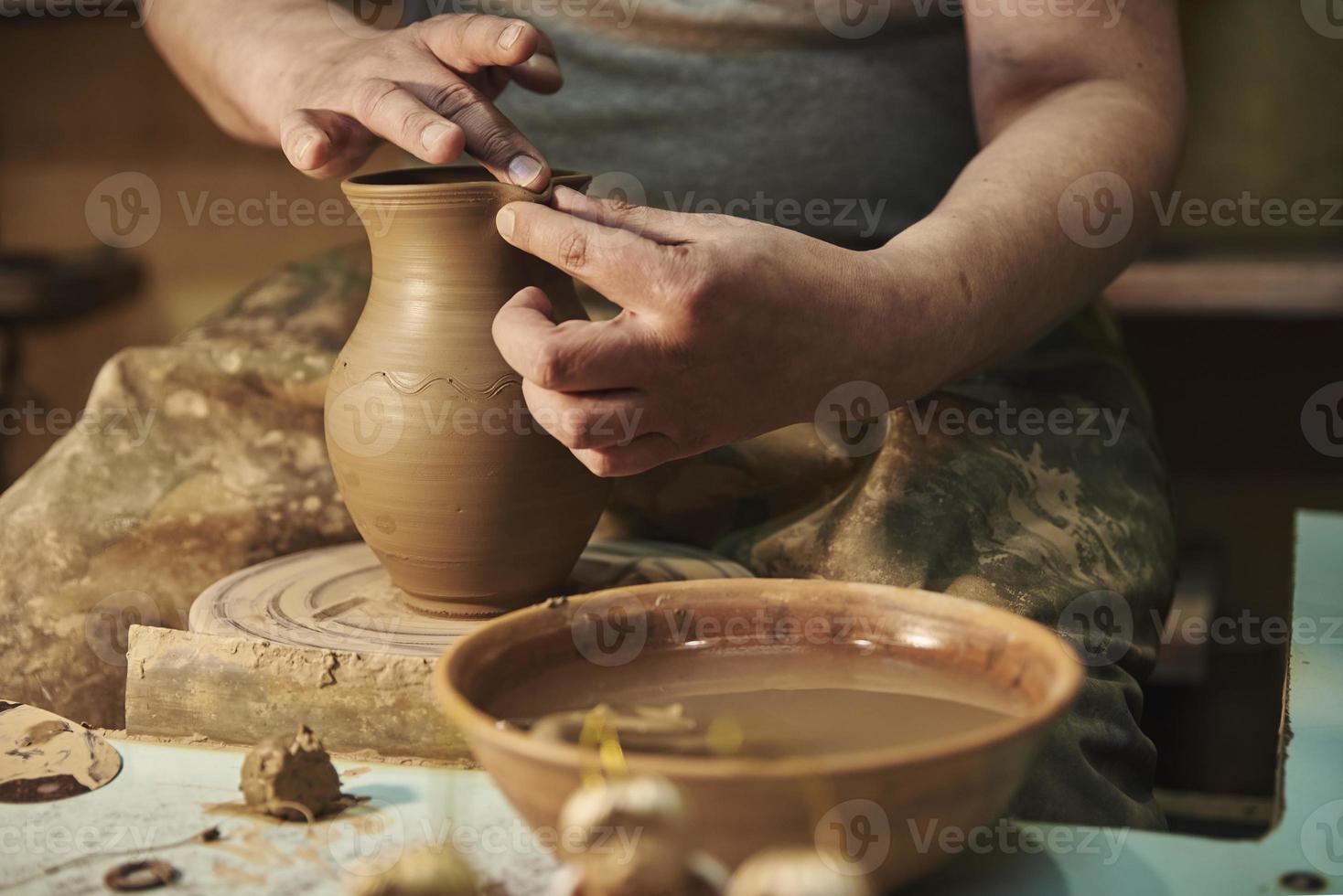 Process of making clay pot on potter's wheel in workshop. Potter at work photo