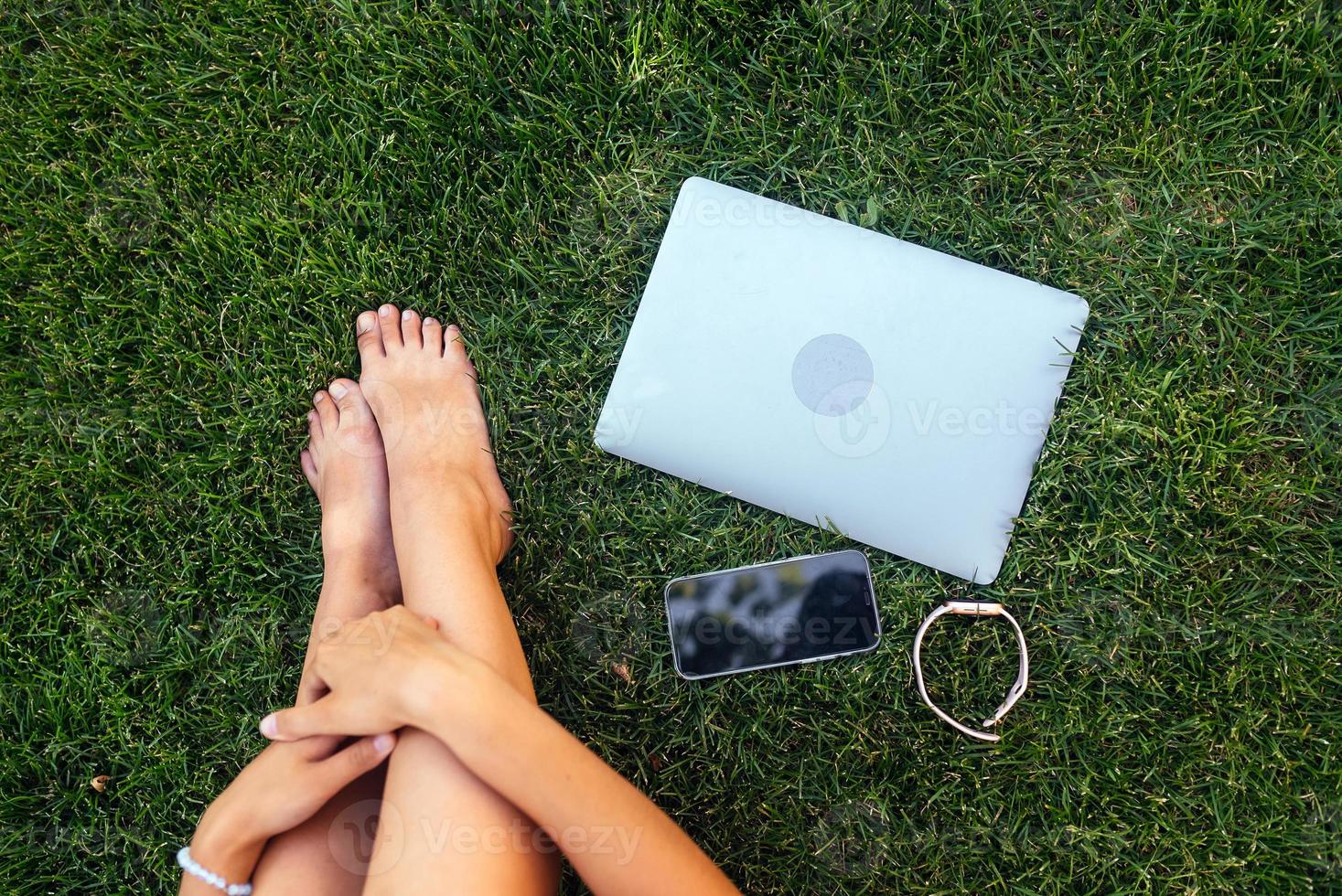 Young fit attractive woman lying on green lawn park. photo