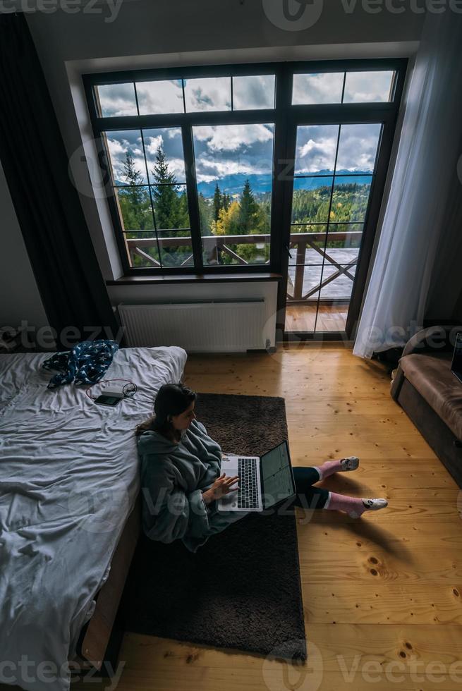 Female with laptop sitting on the floor and working on laptop photo