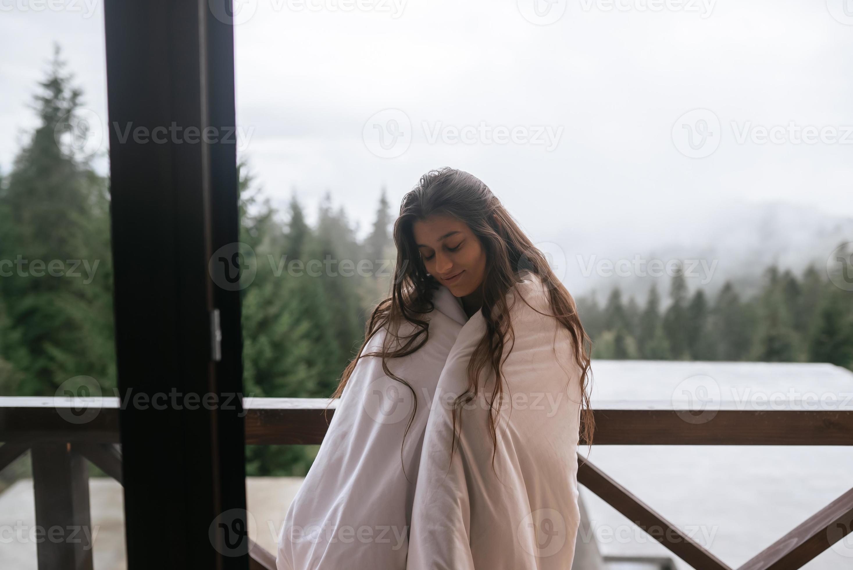 Young woman wrapped in a blanket on the balcony 15496297 Stock Photo at