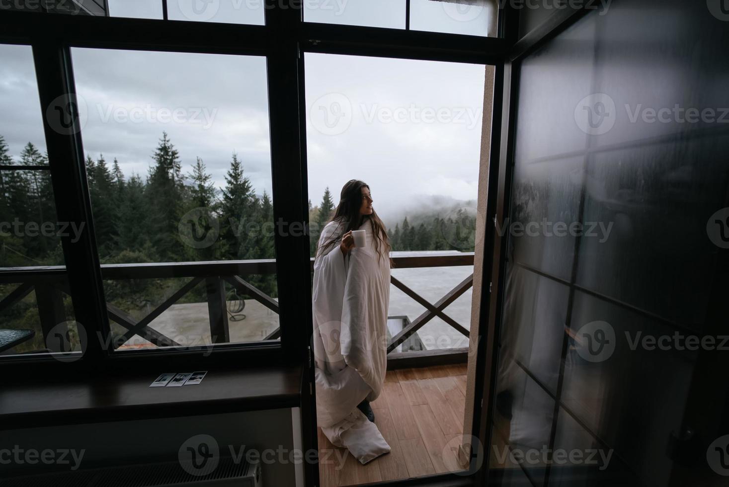Woman drinking tea on cozy balcony of a country house. photo
