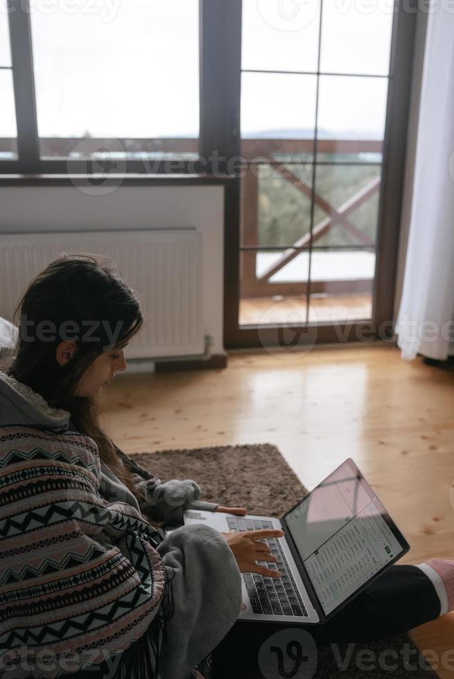 Female with laptop sitting on the floor and working on laptop photo