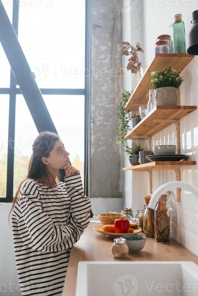 Young woman is thinking about what to cook for breakfast photo