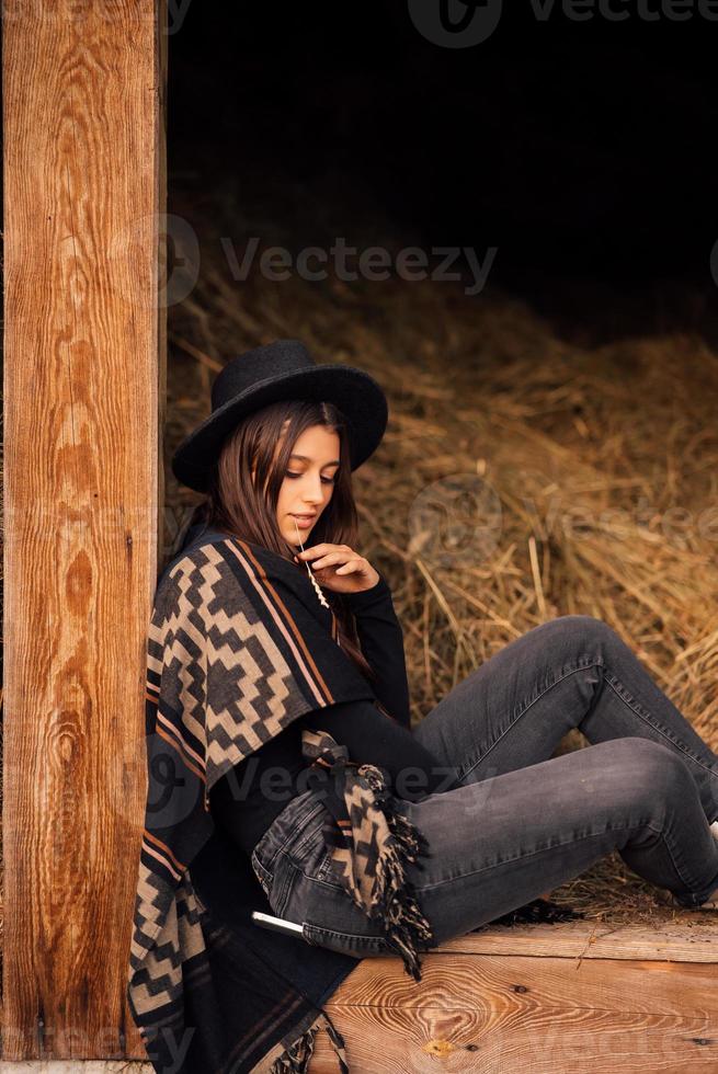 Young brunette woman sitting at the barn. Country style. photo
