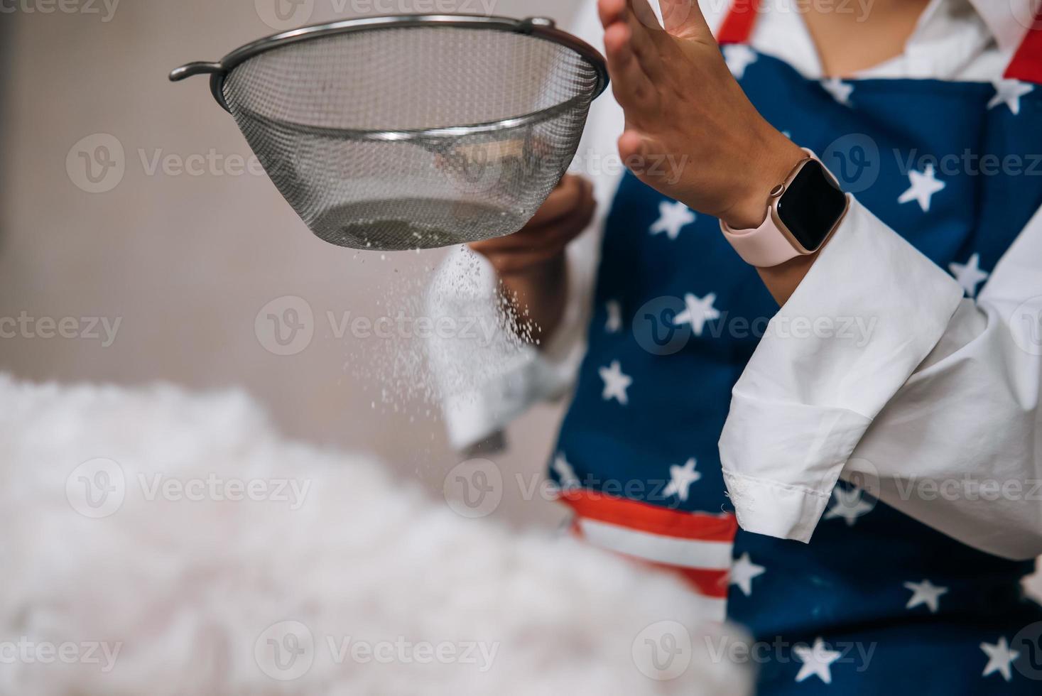 mujer en la cocina tamiza la harina junto con un perro foto
