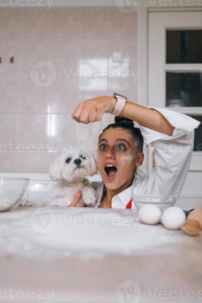 Woman is playing with a dog while pouring flour photo