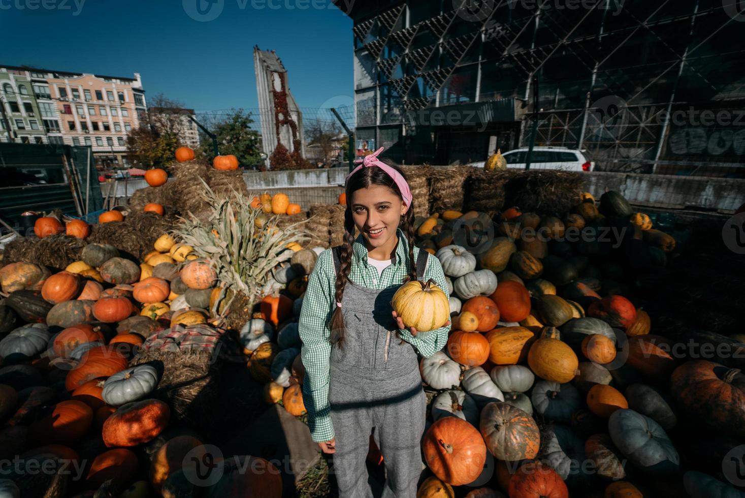 Woman with a small pumpkin among the autumn harvest photo