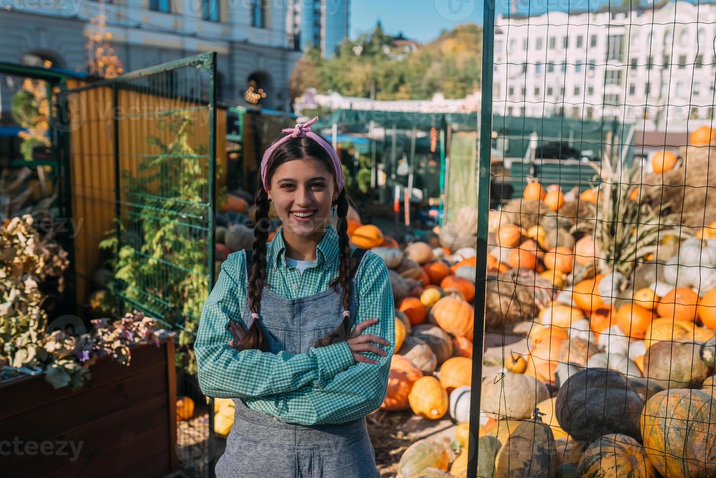 Farmer woman sells autumn pumpkin harvest at the market photo