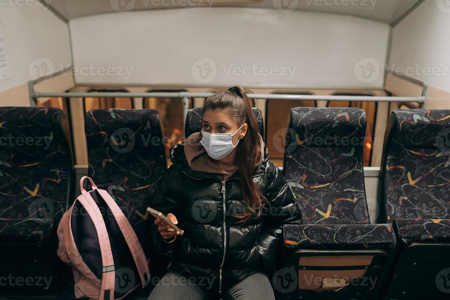 Young woman with mask traveling in the public transport. photo