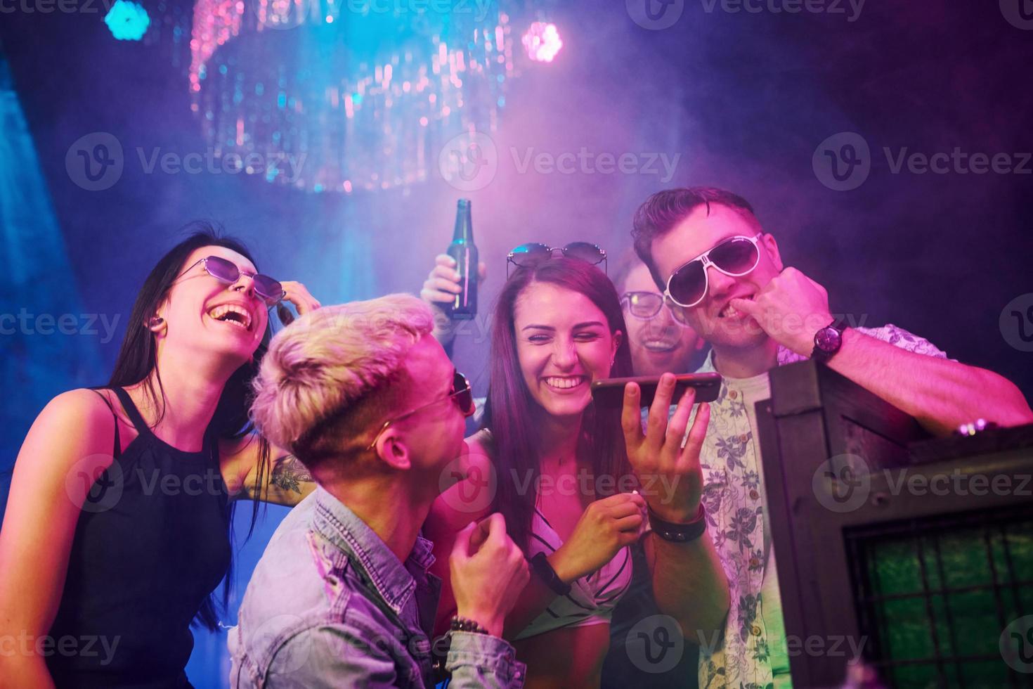 Young people is having fun in night club with colorful laser lights photo