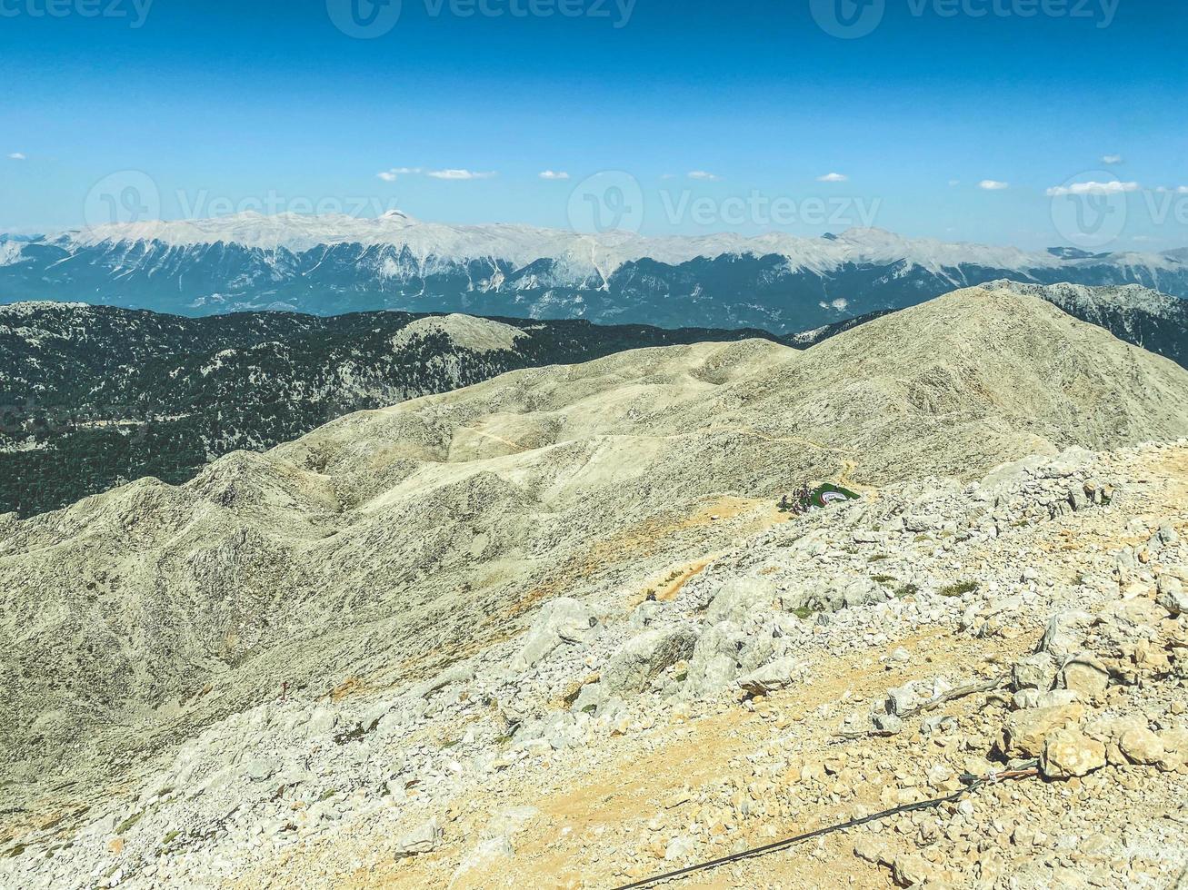 rest in a hot country with mountains near the water. observation deck on a mountain with grass and sand. sandstone texture. mountain with greenery photo