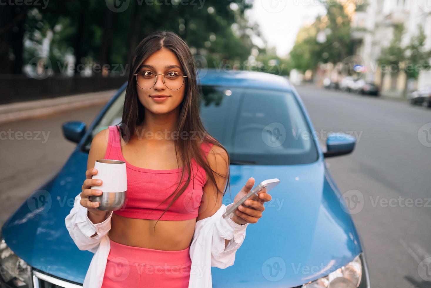 mujer conducir coche detener pausa para tomar café, usar teléfono inteligente foto