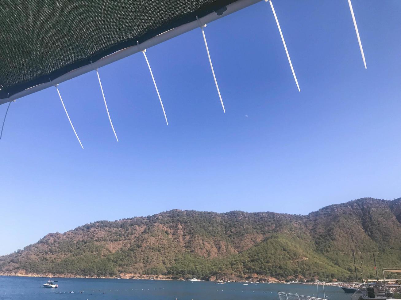 yacht tour. the top of the yacht is sheathed with a net from the wind. roof covering made of thin threads. mountain view from greenery and bushes photo