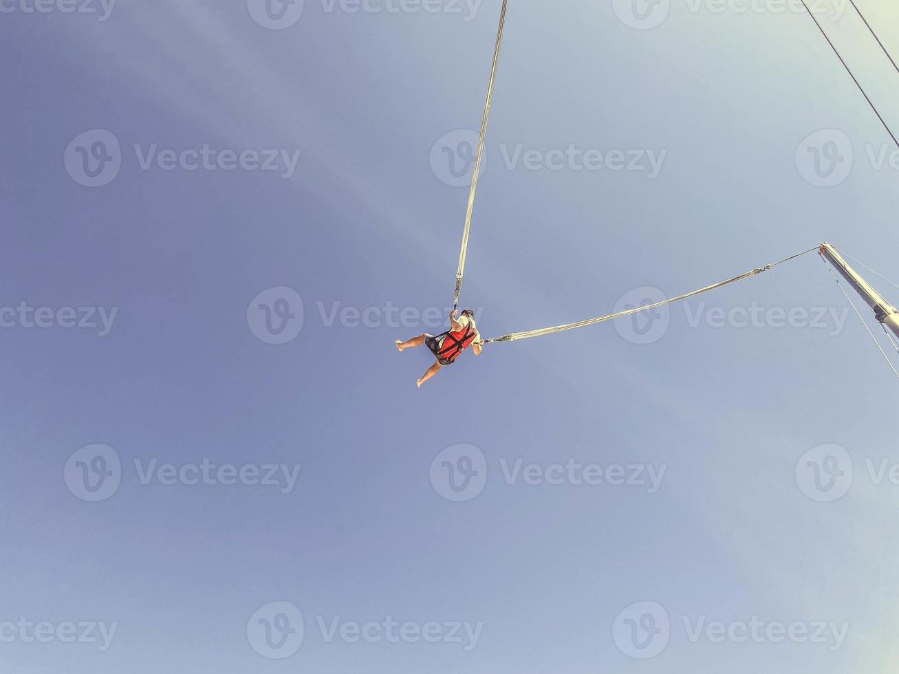 catapult on top of the mountain. entertainment for tourists, active recreation. jump up on a huge elastic band, a man in equipment, a protective suit flies on a catapult photo