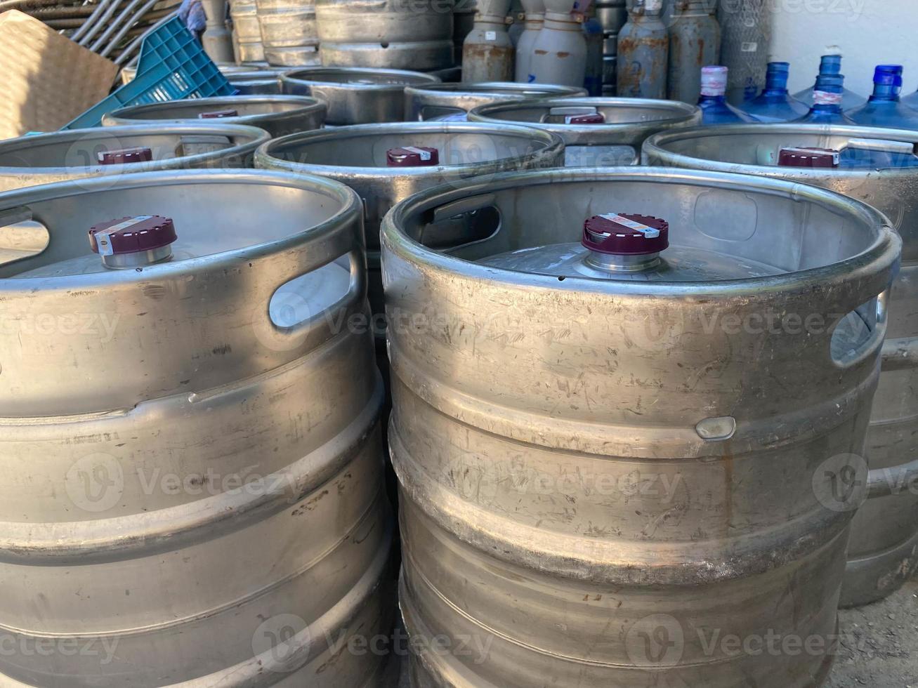 Closeup heap of shiny stainless steel beer kegs photo