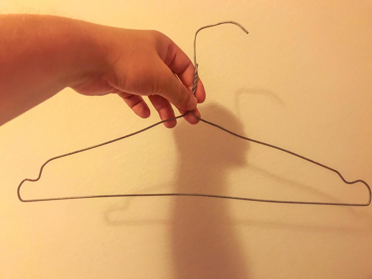 homemade wire hanger for clothes. clumsy, uneven hanger with your own hands. storing clothes in a poor man's wardrobe photo