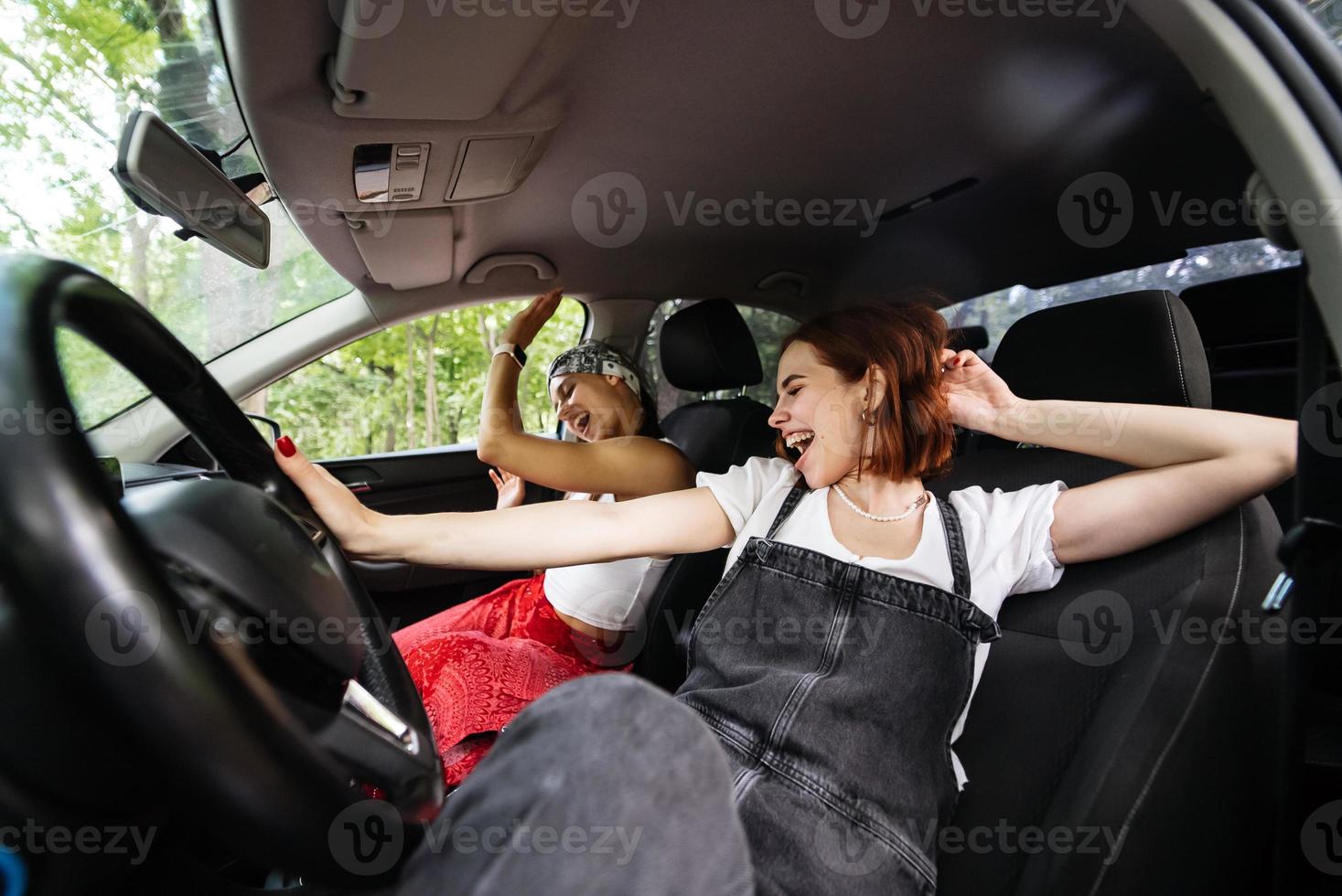 Young females on a road trip traveling by a car. photo