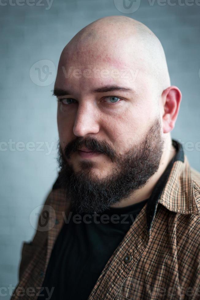 retrato de un hombre calvo en una camisa con barba foto