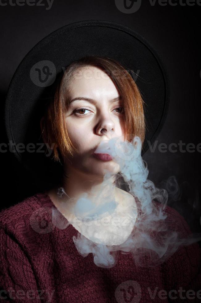 Portrait of a young girl in the smoke of cigarettes photo