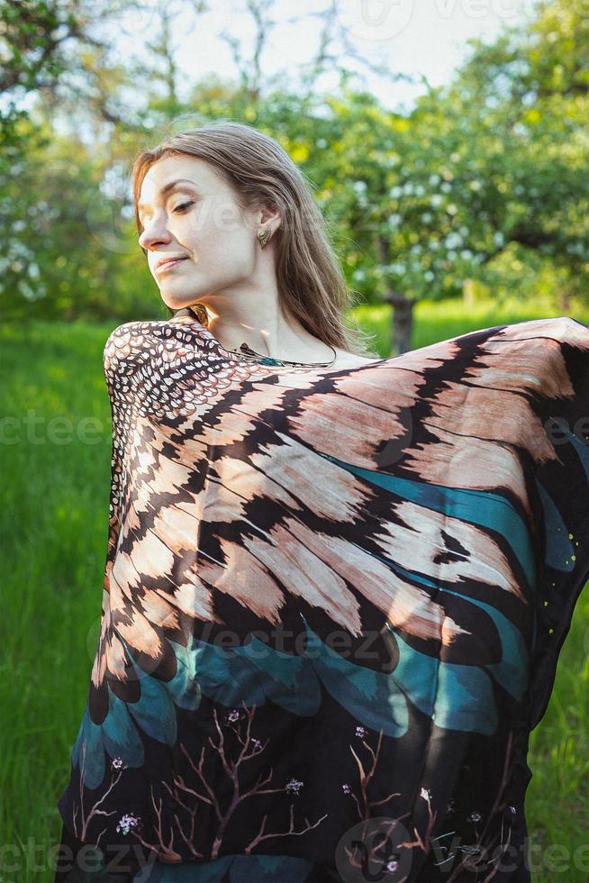 Woman covering shoulders with feathered wing shawl scenic photography photo