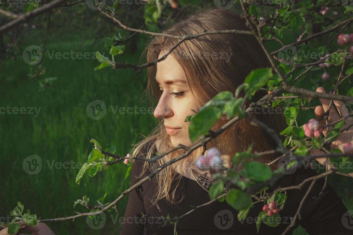 Close up woman touching tenderly cherry blossom branch portrait picture photo