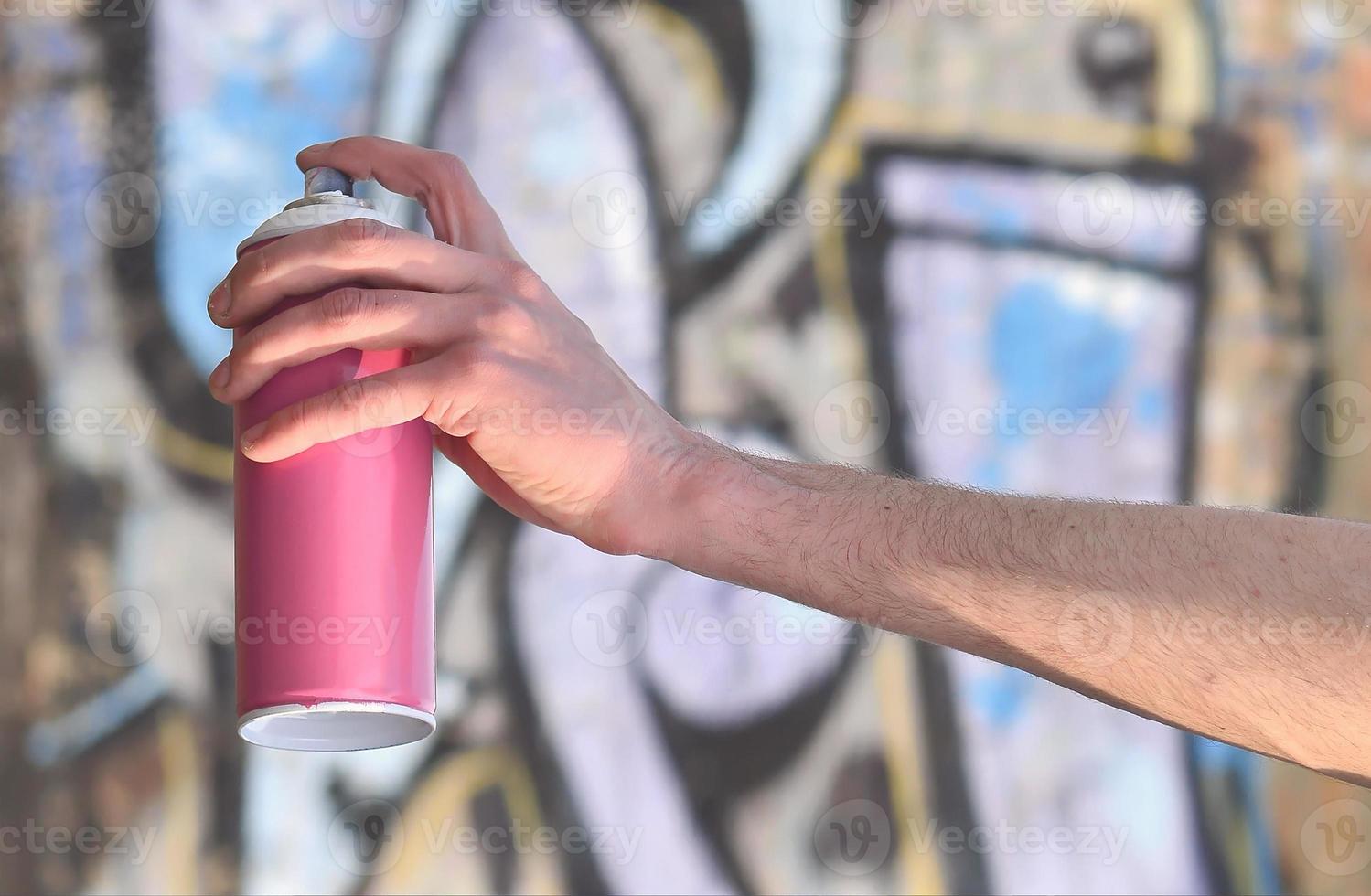 Photo of the hand of a street artist who draws a new color pictu