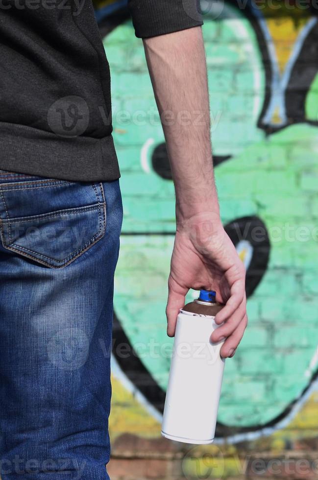 Rear view of a guy drawing a wall with aerosol paint photo