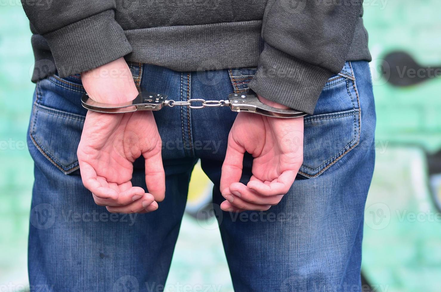 Rear view of the arrested and handcuffed offender against the gr photo