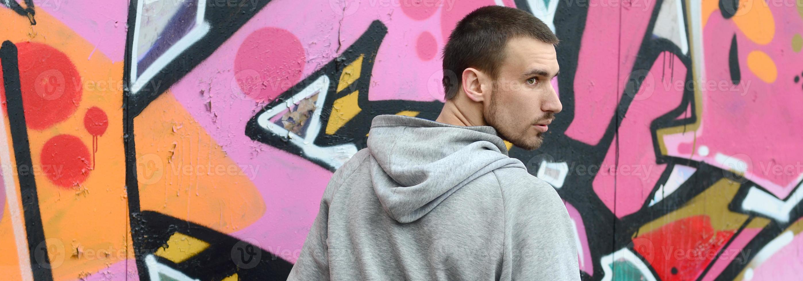 A young graffiti artist looks around while drawing. Vandal tries photo