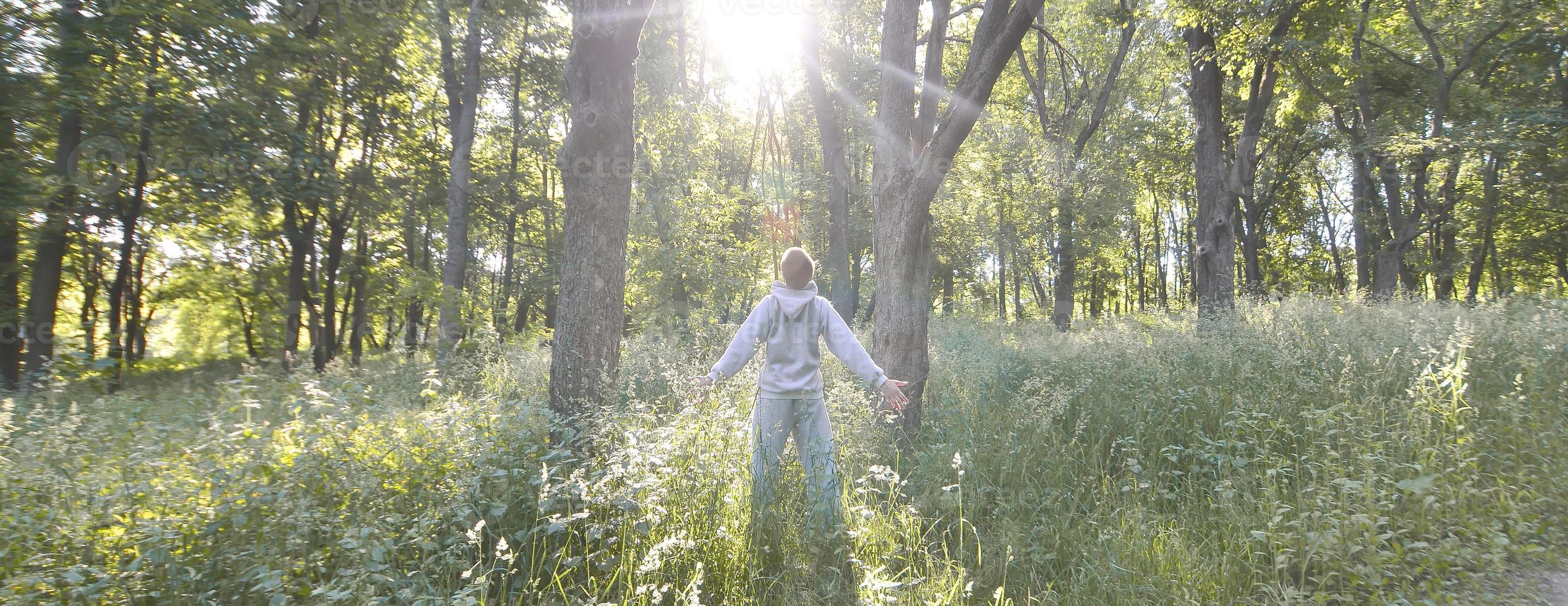 A young guy in a gray sports suit rejoices in the rising of the photo