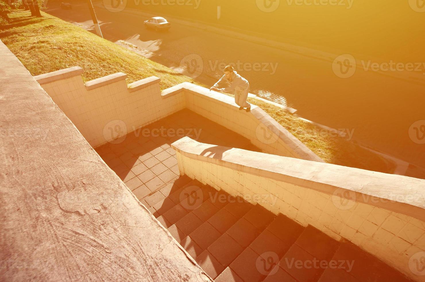 A young guy performs a jump through the space between the concrete parapets. The athlete practices parkour, training in street conditions. The concept of sports subcultures among youth photo