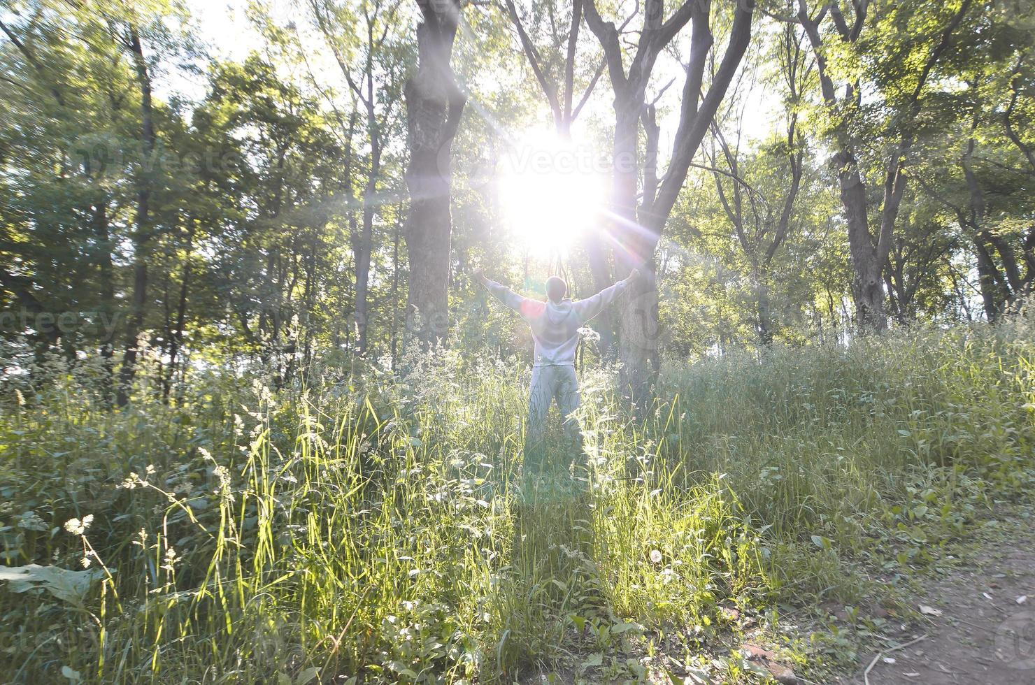 A young guy in a gray sports suit rejoices in the rising of the photo