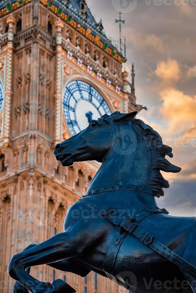 vista de cerca de la torre del reloj big ben y el monumento a la estatua del caballo en primer plano. foto