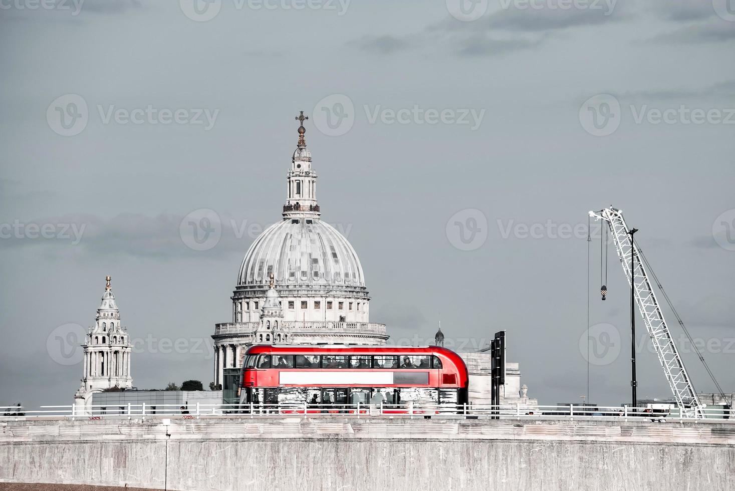Red double decker bus crossing a bridge in London, England. photo