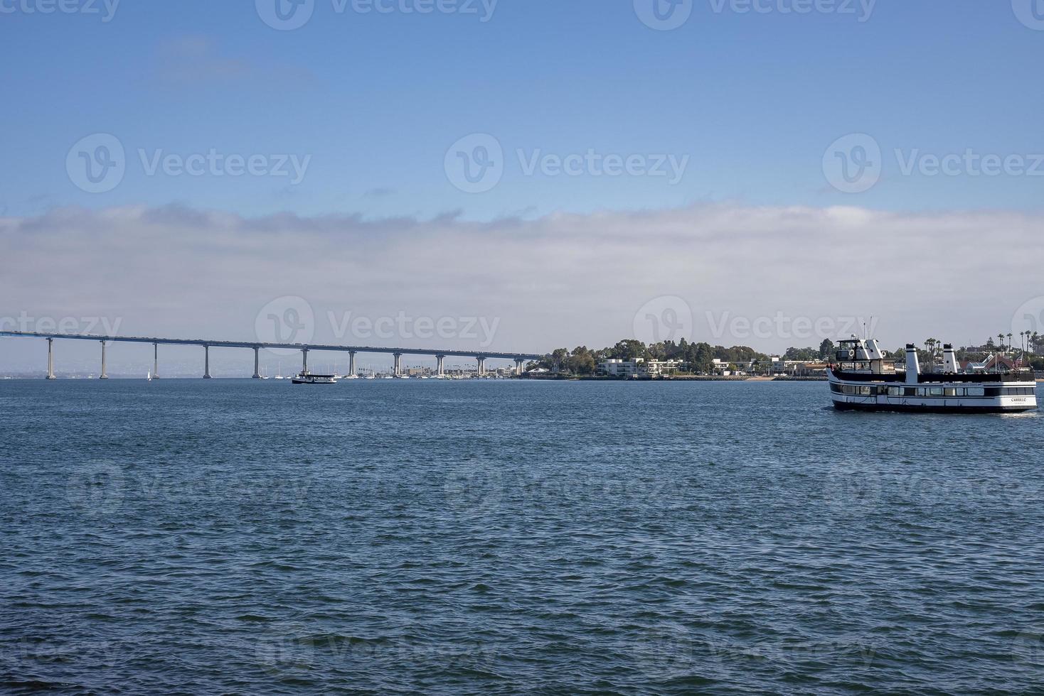 Distant view of Coronado bridge over San Diego sea during sunny day photo