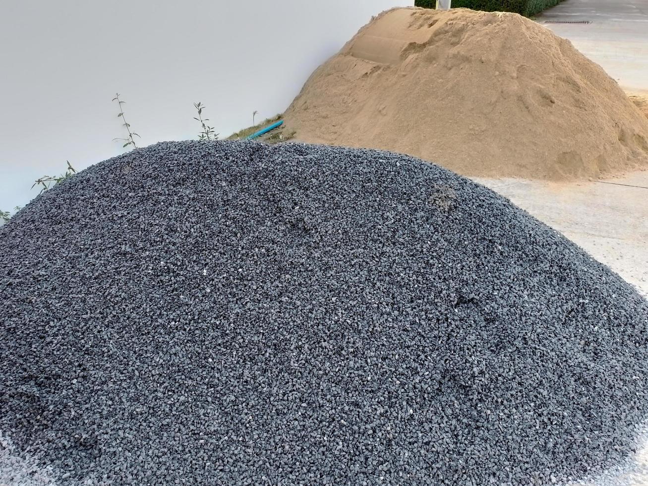 A pile of crushed stone and a pile of sand at the construction site. photo