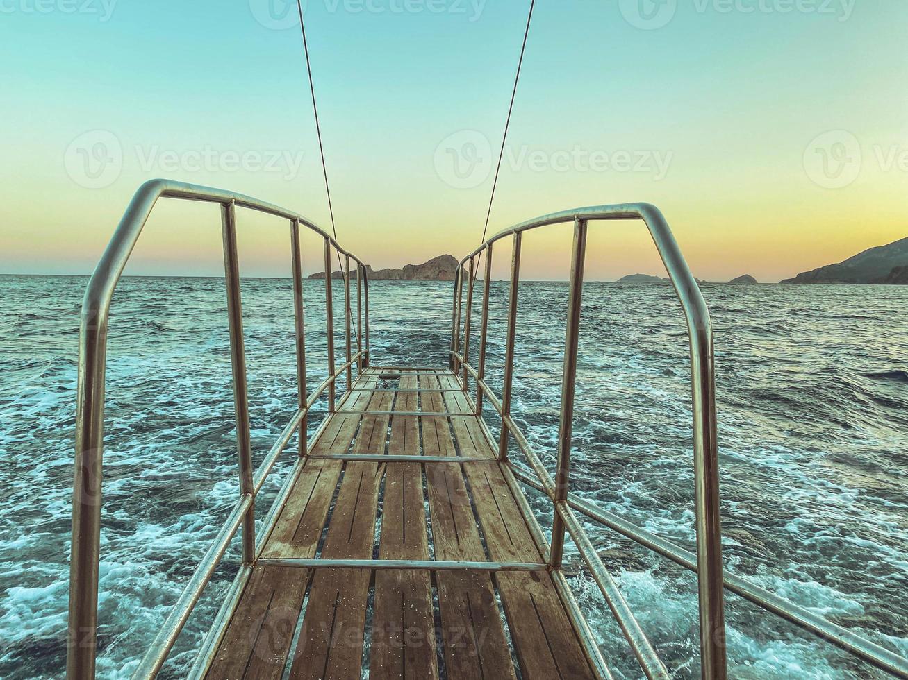 bridge made of wood with metal breaks into the sea. water with white foam, blue waves. bridge on a yacht for swimming and diving. leisure photo