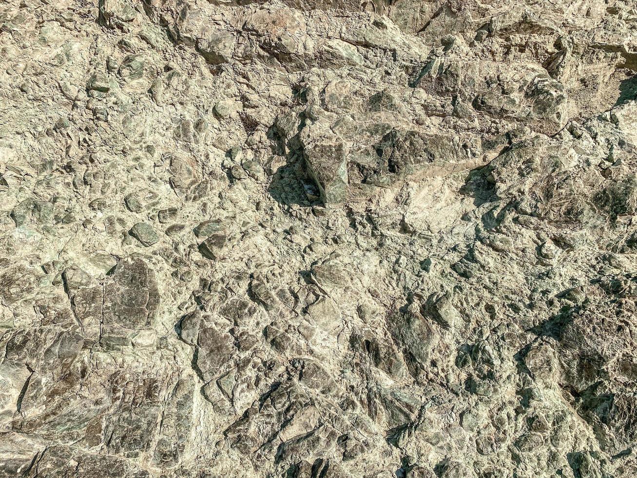 mountain texture. volumetric 3d background with a rock of stones and sand. rock with holes and burrows. solid stone, natural materials background photo