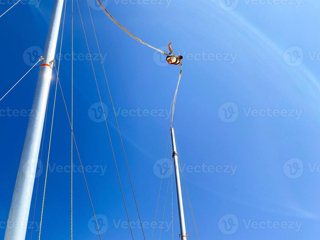 catapult on top of the mountain. entertainment for tourists, active recreation. jump up on a huge elastic band, a man in equipment in a catapult photo