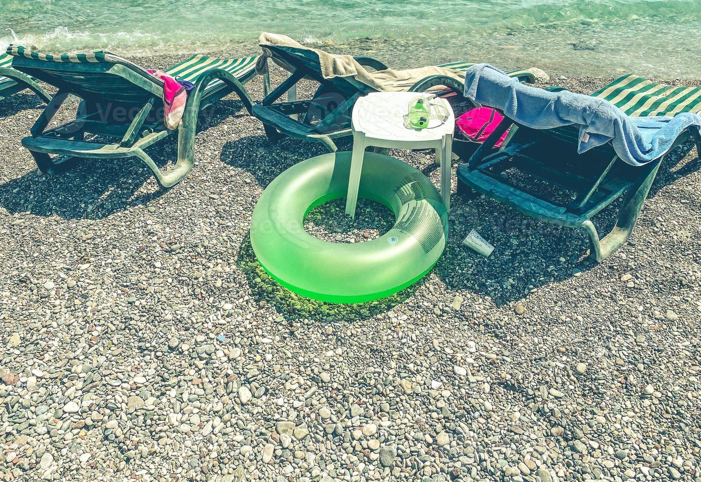vacation by the sea on the beach. on the ground are swimming accessories, diving goggles, a light green rubber life buoy for a child photo