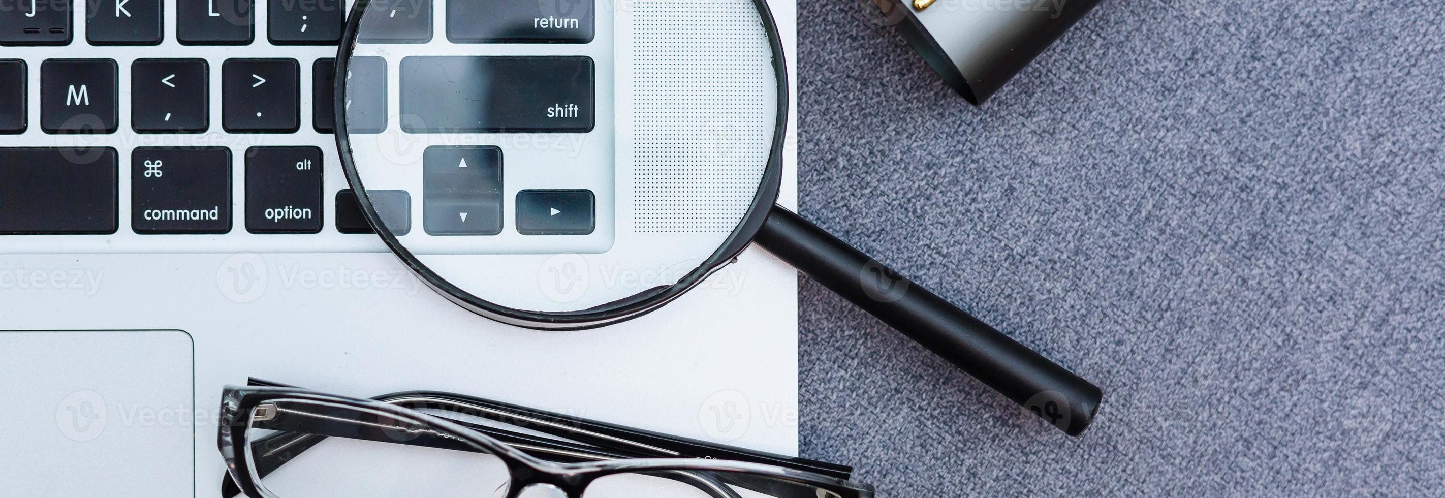 Business summary reports and a magnifying glass with glasses on table office. Concept of Data Analysis, Investment Planning, Business Analytics. photo