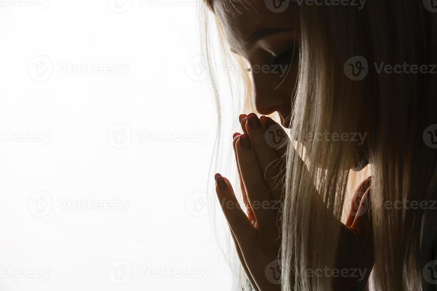 Beautiful redhead freckled young teen girl prays. Close up portrait of a female praying photo