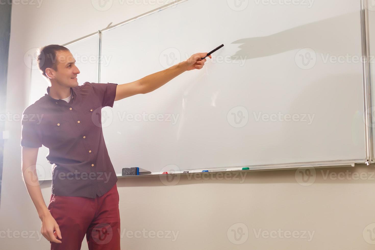 Male teacher listening to students at adult education class photo
