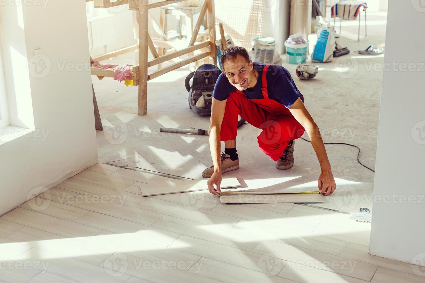 Installing ceramic floor tiles - measuring and cutting the pieces, closeup photo