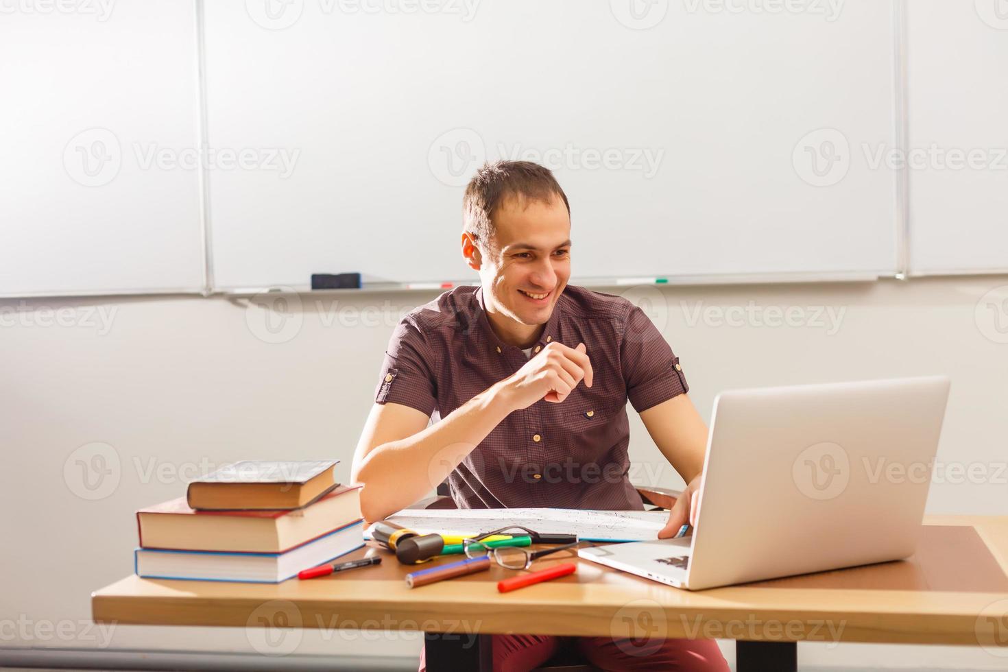 Male teacher listening to students at adult education class photo