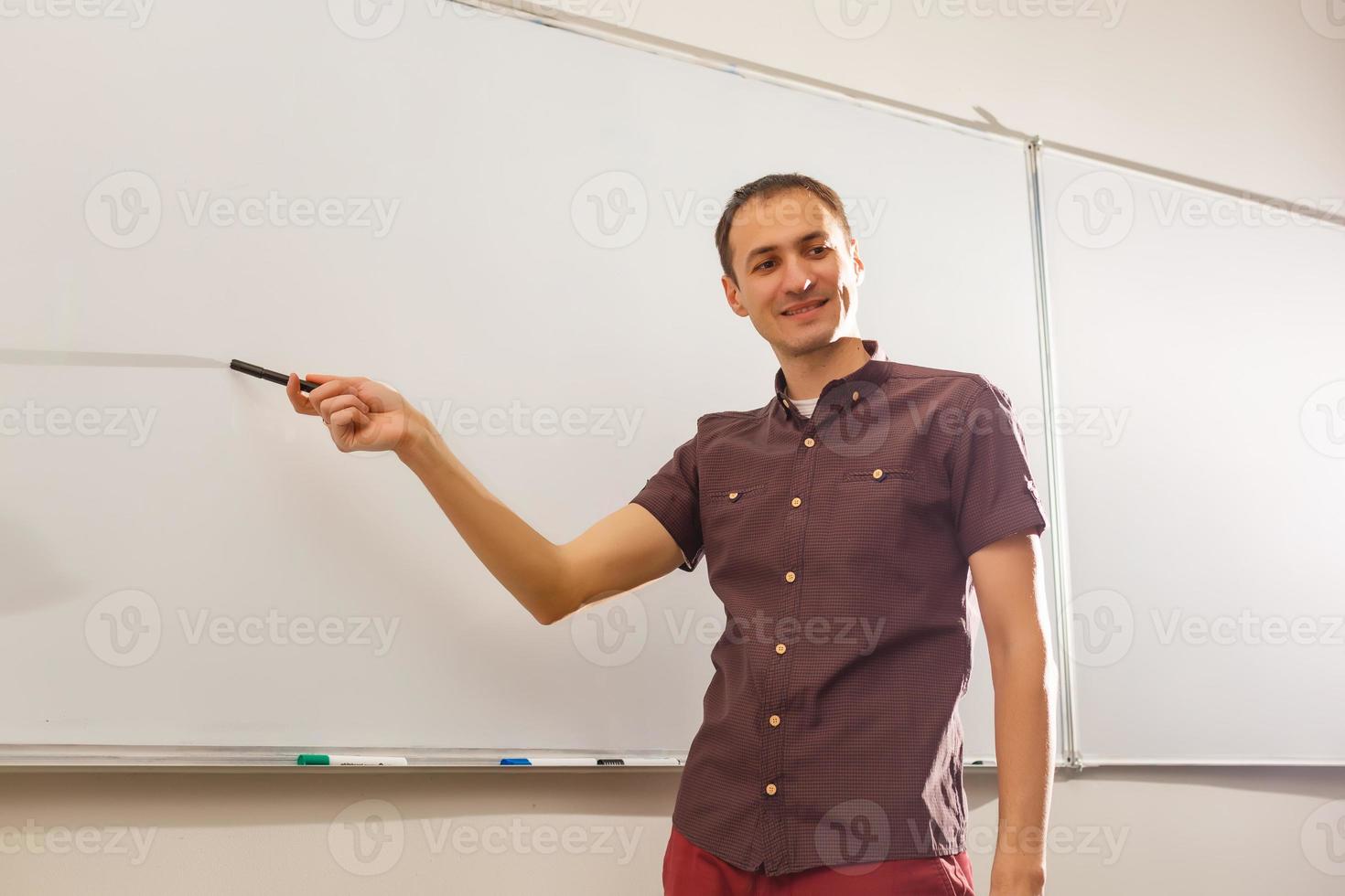 Male teacher listening to students at adult education class photo