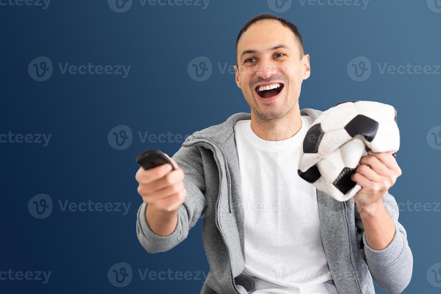 male football fan with a crumpled ball and remote control photo