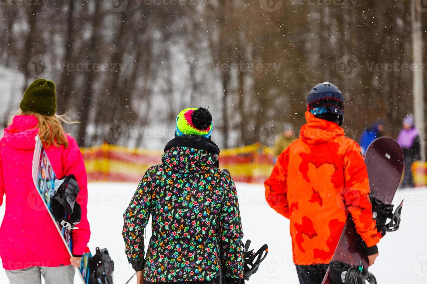 Happy friends going in winter vacation. Young people having fun doing extreme snowboarding photo